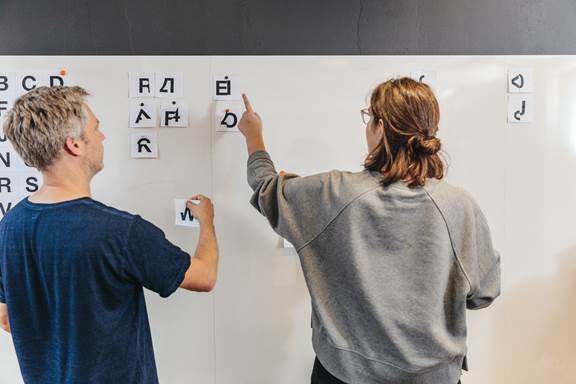 Two designers working on a whiteboard