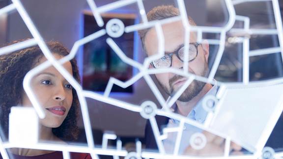 Two individuals looking at digital screen