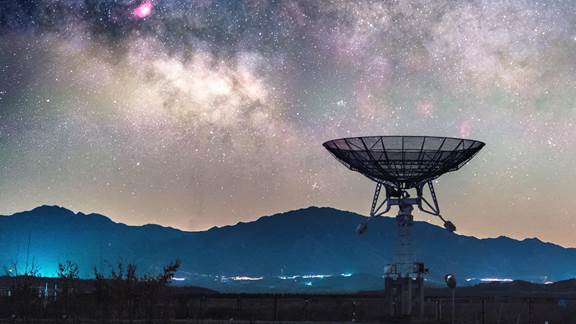 Radio telescope pointing to a starry sky