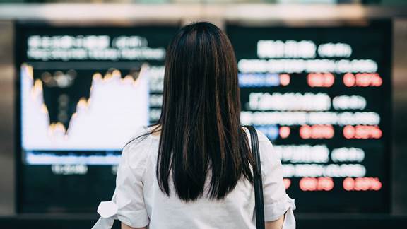 woman looking at a stock exchange screen