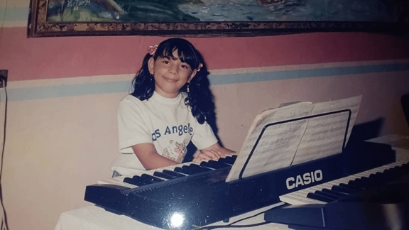 Picture of Laura as a child, playing piano