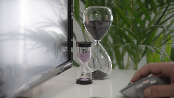 An hourglass next to a computer