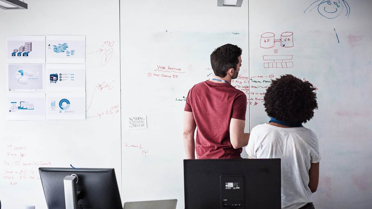 Two people looking at a whiteboard