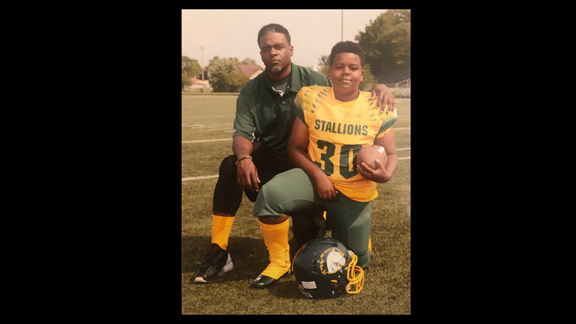 Doc posing with his son for football pictures
