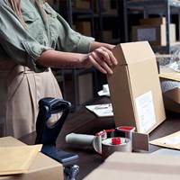 Female business owner packing ecommerce order