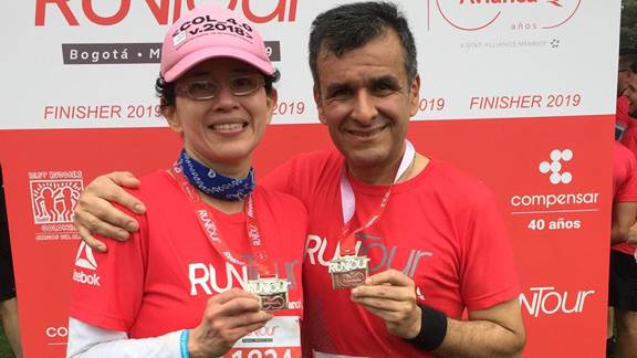 Sonia and Jorge Eduardo at a run race holding medals