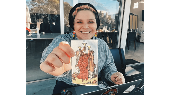 Ara holding a tarot card