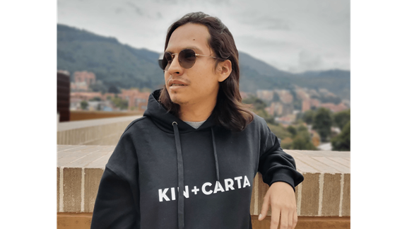 Johan posing in front of Colombian mountains using a Kin + Carta hoodie