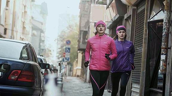 Two girls in sport apparel running in the city