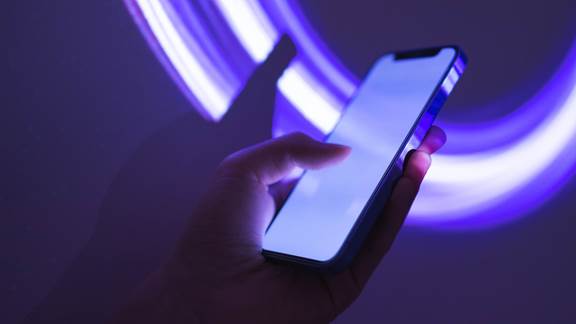 Mobile phone with futuristic purple lights in the background