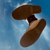 Photo of somebody jumping, taken from underneath. You can see their feet and the blue sky